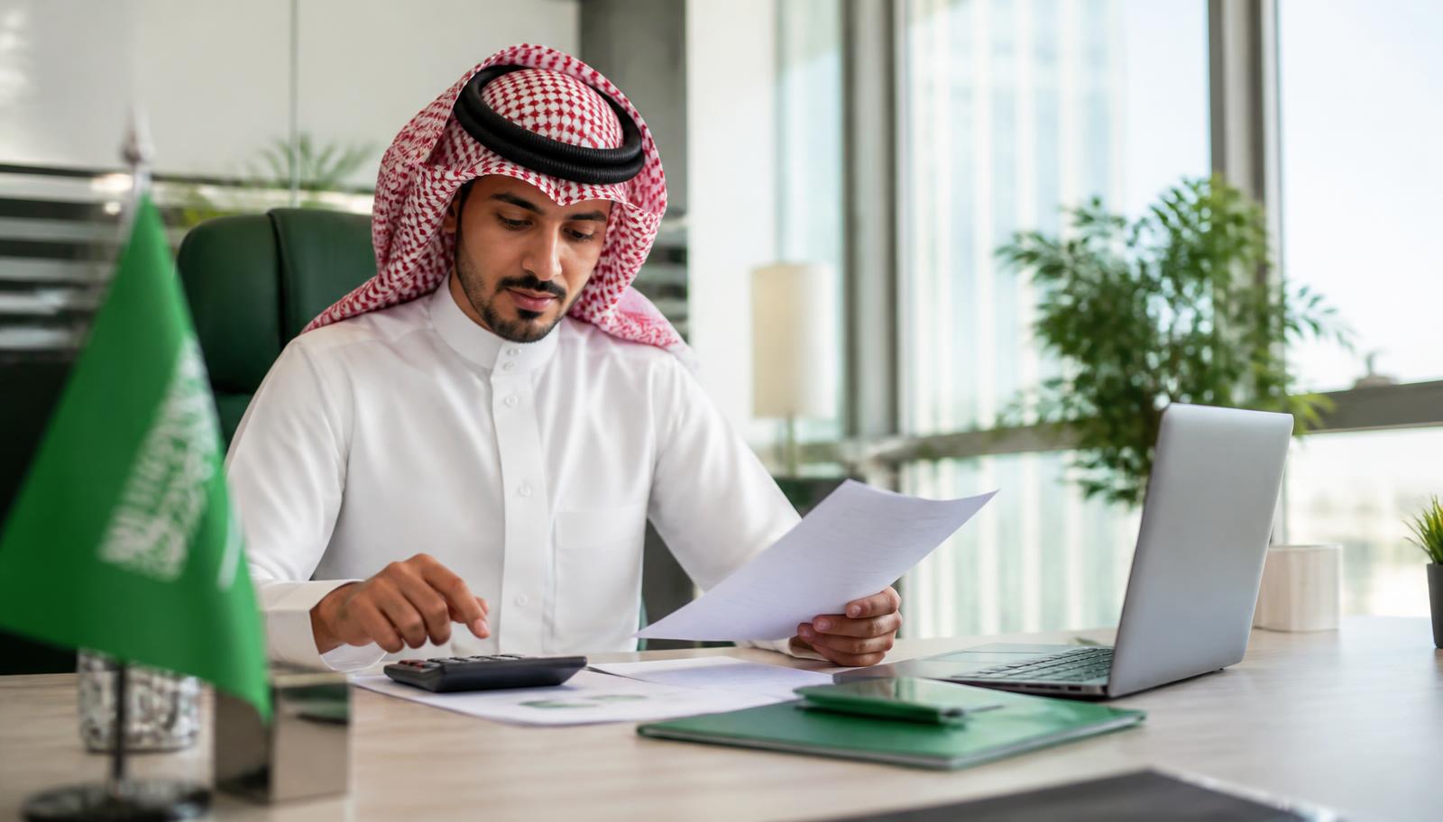 مستشار مالي يراجع مستندات التمويل وحاسبة القسط